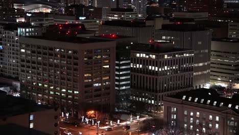 rooftop-wet-winter-night-view-of-downtown-city-buildings-stadium-reflection-partial-post-modern-historic-buildings-lit-trees-and-post-lights-festive-style-Christmas-quite-small-diagnol-birds-eye-view