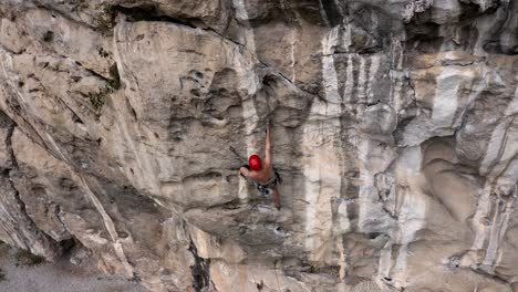 Male-rock-climber-climbing-steep-rock-face-in-Getu-Valley,-China,-aerial-view