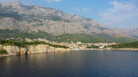 Amazing-Makarska-town-on-Croatia-Adriatic-Sea-coastline,-aerial-pull-back-reveal