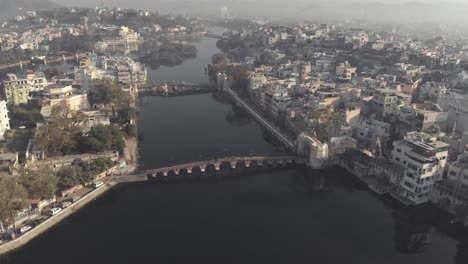Blick-Von-Oben-Auf-Die-Daiji-Brücke-Und-Die-Chand-Pole-Brücke-über-Den-Pichola-See-In-Udaipur,-Rajasthan,-Indien---Panoramaaufnahme-Aus-Der-Luft