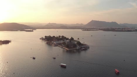 4k-aerial-drone-footage-of-the-Taj-Lake-Palace-on-Lake-Pichola-during-sunset-near-the-city-of-Udaipur,-India