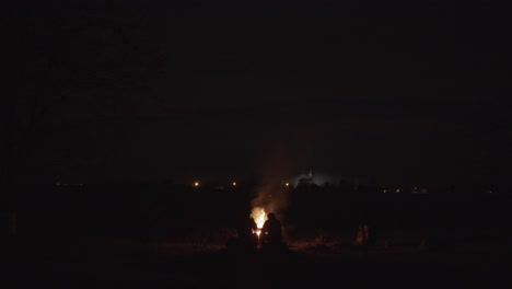 Men-Sitting-AroundSparkling--Campfire-Dark-Night,-Center