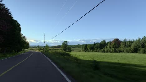 Car-driving-on-a-calm-and-empty-rural-road-on-a-sunny-day