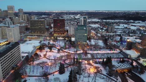 1-3-aerial-flyer-over-winter-frestive-city-riverside-historic-ledgislature-park-skyline-hometown-forest-nature-sleigh-bells-Christmas-lights-on-buildings-trees-paths-to-subway-system-underground-mall