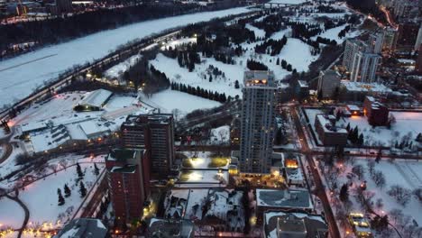 1-2aerial-birds-eye-view-flydown-night-time-over-winter-futuristic-modern-residential-rivers-edge-high-rises-by-golf-course-indoor-tennis-club-cross-country-skiing-snow-shoeing-posh-upscale-university