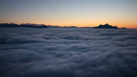 Day-to-night-sunset-time-lapse-above-a-cloud-inversion-in-the-Swiss-Alps-as-seen-from-Rigi,-Switzerland-with-a-view-of-the-mountains-and-stars