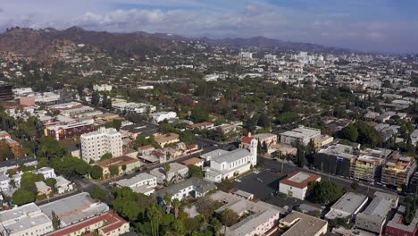 Panning-aerial-shot-above-West-Hollywood-neighborhood-with-Hollywood-in-the-distance
