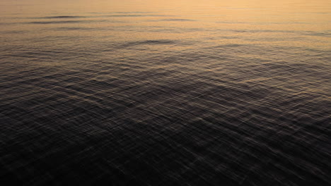 Ruhige-Ozeanwellen-Mit-Reflexion-Des-Sonnenuntergangslichts-Auf-Der-Oberfläche