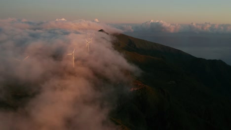 Incredible-magical-mist-flows-over-mountains-with-wind-turbines-spinning-blades