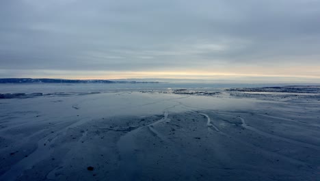 Luftaufnahme-über-Dem-Wasser-Am-Ufer-Eines-Strandes-Im-Winter-In-Charlevoix