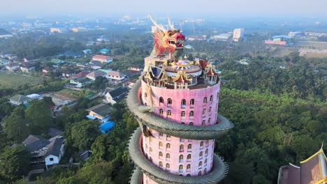 4k-Sunrise-Cinematic-footage-panning-around-The-Wat-Samphran-Temple-with-huge-dragon-coiled-around-and-protecting-it-in-Amphoe-Sam-Phran-province-in-Bangkok,-Thailand