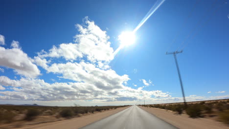 Conduciendo-Hacia-El-Oeste-Hacia-La-Luz-Del-Sol-Y-El-Paisaje-Nuboso-Sobre-El-Desierto-De-Mojave---Hiperlapso-De-Punto-De-Vista