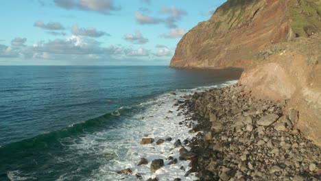 Waves-breaking-on-beach-filled-with-large-volcanic-boulders-in-Madeira