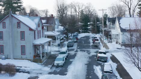 Absteigende-Luftaufnahme-Traditioneller-Häuser-In-Amerikanischen-Kleinstädten-Während-Der-Winterschneeszene