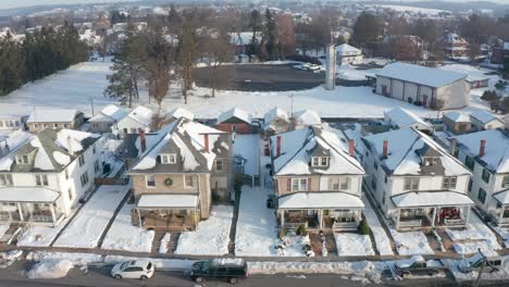 Establishing-shot-of-large-houses-in-United-States,-homes-line-small-town-street-in-America,-USA-housing-residential-community-neighborhood-during-winter