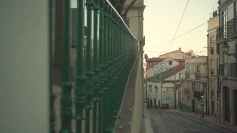 Lissabon-Alfama-Alte-Mittelalterliche-Vintage-Straße-Mit-Hausdächern,-Eisenbahn,-Steinpflaster,-Eisenzaun,-4k