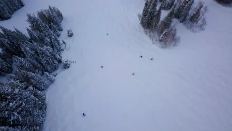 Skiers-and-Snowboarders-race-down-the-side-of-a-snow-packed-mountain-side-in-Utah