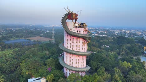 4k-Cinematic-Drone-panning-around-The-Wat-Samphran-Temple-with-huge-dragon-coiled-around-and-protecting-it-in-Amphoe-Sam-Phran-province-in-Bangkok,-Thailand