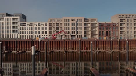 Außenfassaden-Von-Im-Bau-Befindlichen-Wohngebäuden-Im-Stadtteil-Noorderhaven-Und-Freizeithafen-Im-Vordergrund,-Die-Sich-Im-Wasser-Im-Vordergrund-Spiegeln