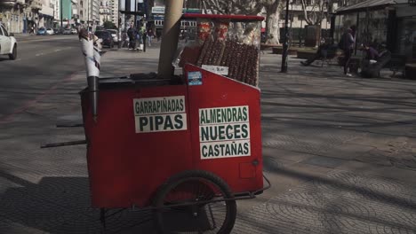 Pan-tilt-up-shot-of-street-food-cart-selling-nuts-in-Montevideo,-Uruguay