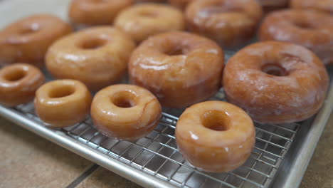 Homemade-Glazed-Donuts-on-Cooling-Rack-with-Mini-and-Full-Size,-Handheld-Detail
