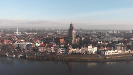 Aerial-ascend-showing-the-Dutch-Hanseatic-medieval-city-of-Deventer-in-The-Netherlands-with-the-river-IJssel-at-sunrise
