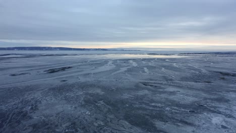 Drone-flying-over-the-frozen-shore-of-the-river-in-Charlevoix