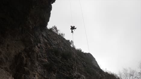 Rock-climber-getting-down-a-rope-from-a-high-rock