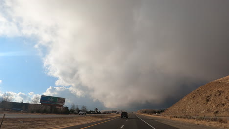 Cumulus-storm-clouds-gather-in-the-sky-above-the-highway-in-this-driver-point-of-view-hyper-lapse-through-the-Mojave-Desert