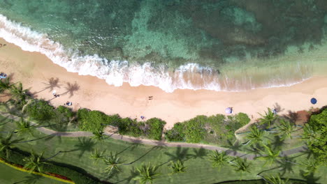 Top-down-view-of-calm-waves-golden-sand-Napili-Beach-on-Maui-Island,-Hawaii,-USA