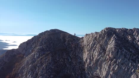 Solo-adventure-of-a-female-hiker-hiking-on-a-rocky-mountain-drone-shot