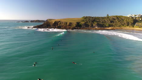 Cinematic-drone-shot-of-surfers-riding-waves-at-Coffs-Harbour-in-Australia