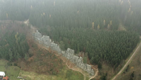 Aerial-Shot-Above-Clouds-Of-A-Rock-Wall-In-A-Breathtaking-Forest-Landscape,-Nature-Destination