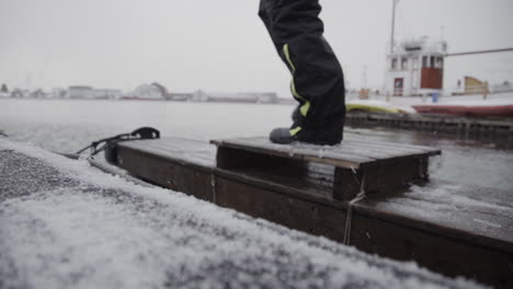 Climbing-frozen-boat-deck-in-freezing-cold-at-harbour-closeup