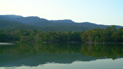 Ang-Kaew-lake-at-Chiang-Mai-University-with-forested-mountain-and-twilight-sky