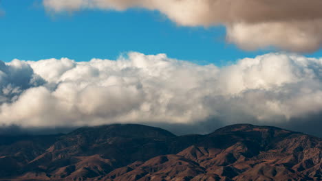 Large-wall-of-cumulus-clouds-gathering-over-the-desert-mountains-in-a-dramatic-updraft---time-lapse