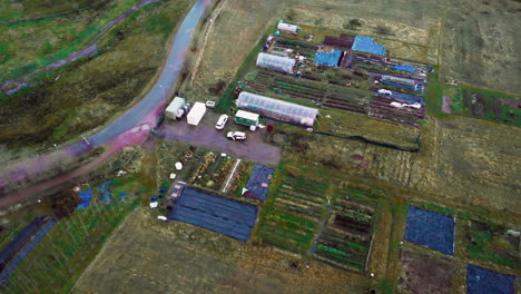 Aerial-view-to-small-Swedish-farm-with-greenhouse-and-fields-around