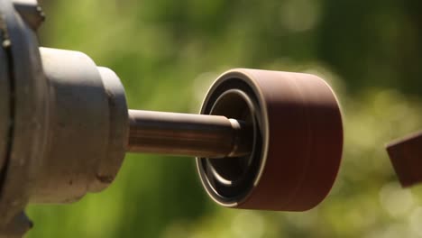 Detail-of-a-man´s-hand-using-a-bench-grinder-on-a-sunny-day