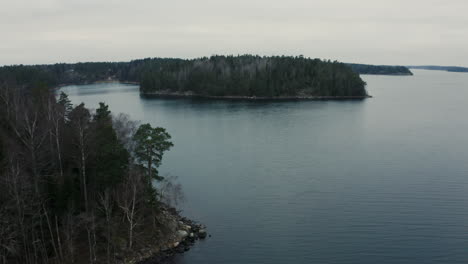 Drone-aerial-of-forest-on-island-in-the-Stockholm-archipelago,-Baltic-Sea