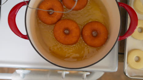 Overhead-View,-Four-Donuts-Deep-Fry-in-Dutch-Oven-Oil,-Slow-Motion