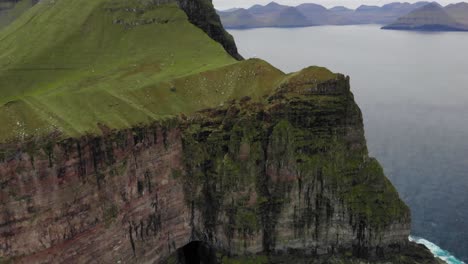 4K-Aerial-of-spectacular-massive-cliffs-with-a-huge-drop-in-the-ocean-on-Kalsoy-on-the-Faroe-Islands-on-a-cloudy-day