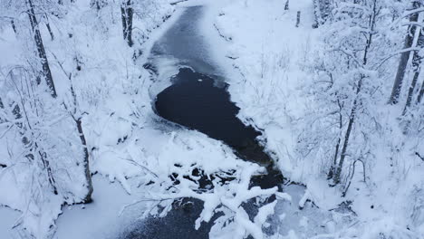 Aerial-drone-video-of-small-partly-frozen-river-in-the-forest