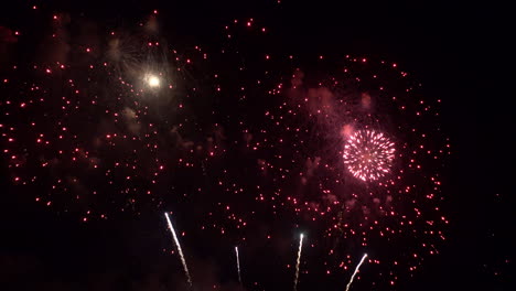 Spektakuläre-Feuerwerksshows-überlagern-Den-Nachthimmel,-Rote-Explodierende-Funken