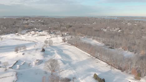 A-short-drone-clip-showing-the-harbor-in-the-distance-and-a-snow-covered-country-club-below