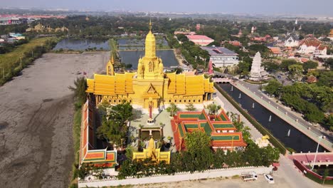 4k-Aerial-of-Beautiful-golden-temple-with-the-golden-standing-buddha-statue-in-the-Ancient-City-park,-Muang-Boran,-Samut-Prakan-province
