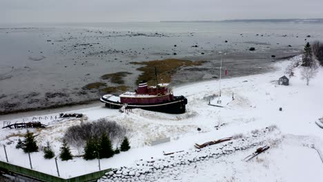 Drone-flying-around-a-docked-ship-on-the-edge-of-the-Saint-Lawrence-River-in-winter