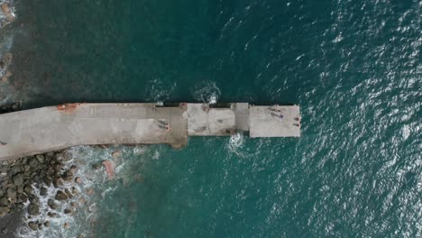 Concrete-pier-at-volcanic-shore-of-Madeira-with-blue-Atlantic-ocean-water