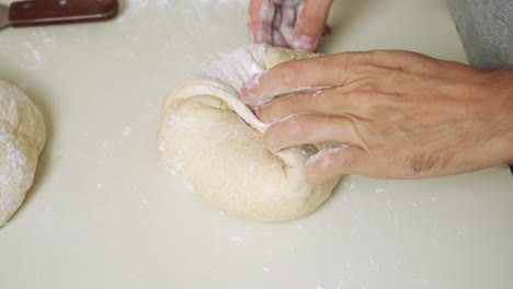 Draufsicht-Auf-Einen-Bäcker,-Der-Den-Teig-Faltet-Und-Zu-Einem-Brotlaib-Formt