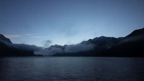Sunrise-time-lapse-of-Lake-Sils-in-Engadin,-Switzerland-as-seen-from-Maloja-on-a-misty-morning-with-a-panoramic-view-of-the-mountains