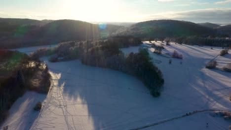 Erstaunliche-Luftschwenks-über-Schneebedeckte-Berge,-Wald-Und-Klaren-Sonnenhimmel-Im-Winter-In-Schwaben,-Deutschland